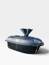 Disperseur d'appât PrintForFishing installé sur un bateau amorceur Quad Bait Boat v2 noir effet carbone au bord de l'eau